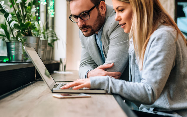 Młodzi ludzie szukają informacji na laptopie